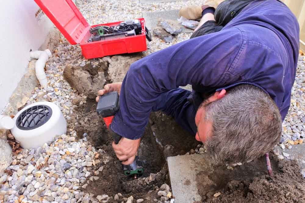 plumber fixing an underground hot water pipe leaking plumber fixing an underground hot water pipe leaking