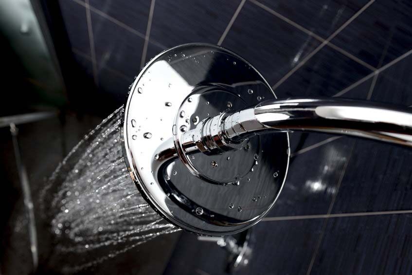 shower closeup of chrome shower head with flowing water